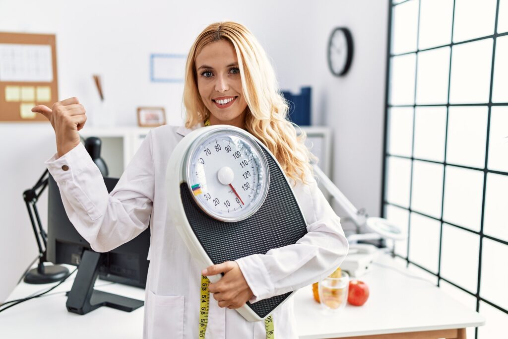 Piekna Blondynka Dietetyk Trzymajaca Wage Laboratoryjna